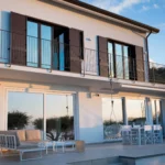 Facciata esterna della villa al tramonto con terrazza panoramica, vetrate e salottino – Villa Giardino degli Ulivi, Sicilia