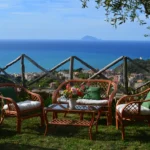 Vista panoramica sul mare da villa con salotto in giardino tra gli ulivi a Capo d'Orlando.