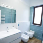 Bagno moderno con piastrelle azzurre, lavabo sospeso, bidet e doccia – Villa Giardino degli Ulivi, Sicilia