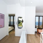 Disimpegno con vista mare da due lati, camera da letto e zona lettura con arredi moderni – Villa Giardino degli Ulivi, Sicilia