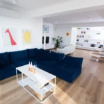 Salotto moderno con divano blu, tavolino bianco e dettagli di design minimal – Villa Giardino degli Ulivi, Sicilia